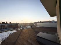 Rozległy taras dachowy z widokiem na panoramę Łodzi o wschodzie słońca