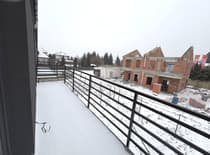 Balkon z czarną balustradą i widokiem na okolicę — dom Ksawerów łódzkie