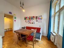 Salon z stołem jadalnym i kanapą na parkiecie w jodełkę w Łodzi