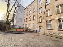 Podwórko kamienicy z ławką i heksagonalną nawierzchnią na Polesiu w Łodzi