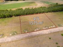 Widok z lotu ptaka na działkę 4/5 o pow. 1575m² — trawiasty teren przy drodze gruntowej