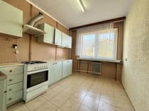 Kuchnia z miętowymi szafkami, kuchenką gazową i firanką w oknie