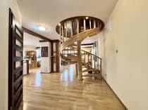 Hol z efektowną drewnianą klatką schodową w kształcie spirali — dom Mścice