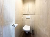 Oddzielna toaleta z miską wiszącą i jasną ceramiką — mieszkanie Łódź-Bałuty