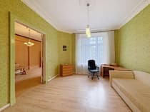 Pokój z biurkiem i sofą – zielone ściany z listwami, jasna podłoga drewniana, mieszkanie Łódź Piotrkowska
