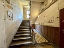 Historyczna klatka schodowa z mozaikową posadzką i drewnianą balustradą — kamienica