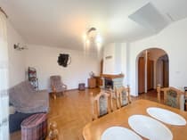 Salon z kominkiem, drewnianą podłogą i łukiem w domu w Brogach