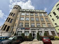 Fasada kamienicy przy ul. Kościuszki w centrum Łodzi z parterowymi lokalami usługowymi