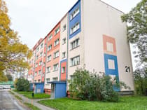Czteropiętrowy budynek mieszkalny z kolorowymi elewacjami w Łodzi.