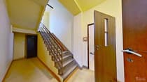 Klatka schodowa kamienicy z metalową balustradą i żółtymi ścianami — Łódź Bałuty
