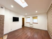 Jasny pokój dzienny z balkonem i drewnianą podłogą — kawalerka Łódź Bałuty 26m²