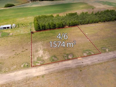 Widok z lotu ptaka na prostokątną działkę zaznaczoną na czerwono, oznaczoną jako 4/6 o powierzchni 1574 m², z drogą gruntową od frontu - idealna dla osób poszukujących działki na sprzedaż Skotniki - łódzkie, w otoczeniu drzew i otwartych pól. biuro nieruchomości