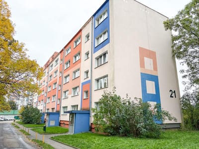 Czteropiętrowy budynek mieszkalny z kolorowymi elewacjami w Łodzi.