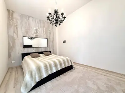 Elegancka sypialnia z kryształowym żyrandolem i tapetowaną ścianą akcentową — Łódź