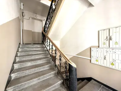 Klatka schodowa z ozdobną kutą balustradą i skrzynkami pocztowymi — kamienica Łódź
