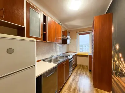 Mieszkanie na sprzedaż Łódź-Polesie 44m² — kuchnia z drewnianymi szafkami i oknem