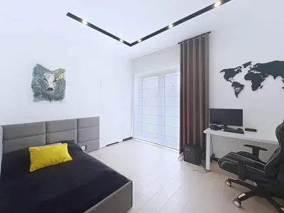 Pokój młodzieżowy z łóżkiem, stanowiskiem gamingowym i balkonem