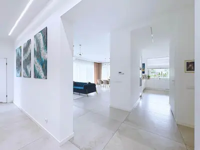 Reprezentacyjny hol z obrazami i otwarciem na salon i kuchnię