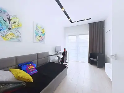 Pokój dziecięcy z łóżkiem, biurkiem gamingowym i wyjściem na balkon