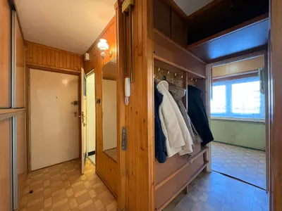 Przedpokój z drewnianą szafą i wieszakiem na odzież — mieszkanie do remontu Łódź-Teofilów