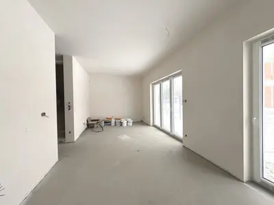 Salon w stanie deweloperskim z dużymi przeszkleniami tarasowymi — dom 115m² Ksawerów