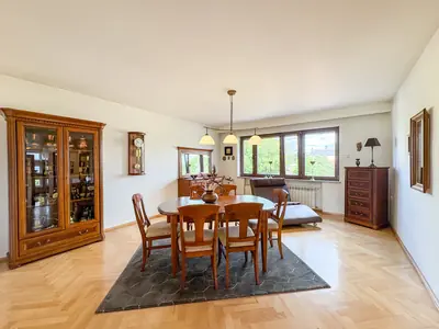 Jadalnia z drewnianym stołem owalnym, witryna i parkiet w domu w Łasku