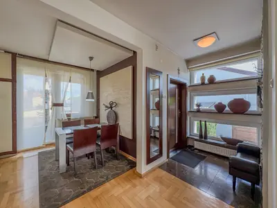 Hol wejściowy z widokiem na jadalnię, dekoracyjne półki przy oknie