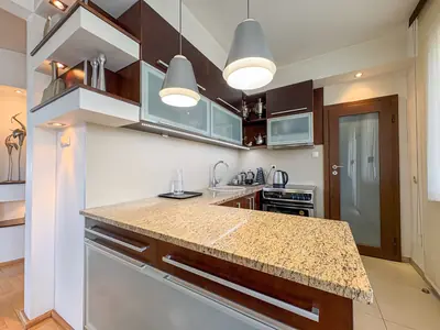 Kuchnia z granitowym blatem wyspowym i ciemnobrązowymi szafkami