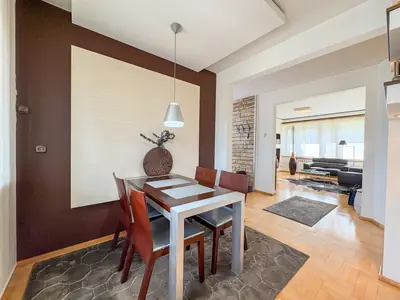 Kącik jadalniany z widokiem na salon, ściana brązowo-beżowa z akcentem