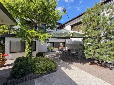 Patio z meblami ogrodowymi i dużym parasolem przy domu w Łasku