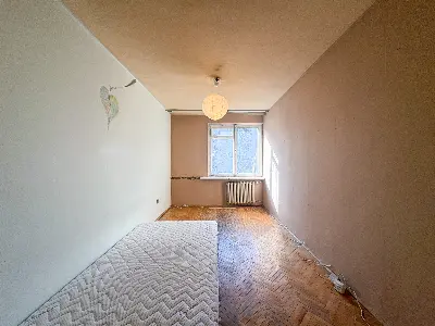 Jasny pokój z parkietem w jodełkę i oknem w bloku na Bałutach