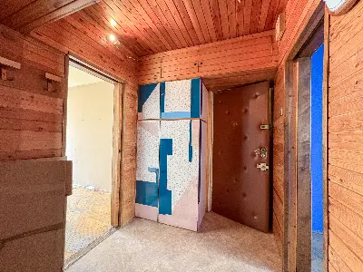 Przedpokój z drewnianą boazerią i kolorowymi drzwiami wejściowymi na Bałutach