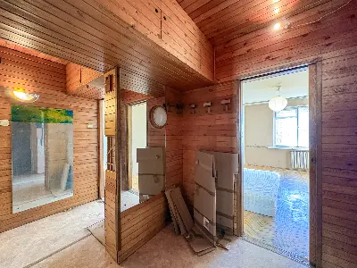 Korytarz z drewnianą boazerią i lustrem w mieszkaniu do remontu w Łodzi