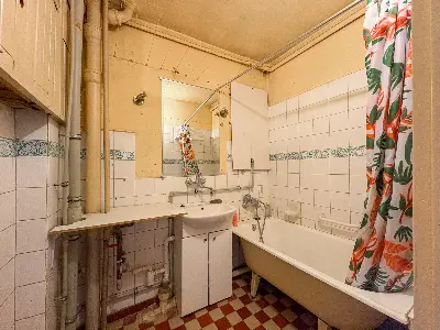 Łazienka z wanną, wzorzystą podłogą i umywalką w bloku w Łodzi