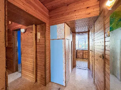 Korytarz z drewnianymi ścianami i wbudowanymi szafkami w mieszkaniu na Bałutach