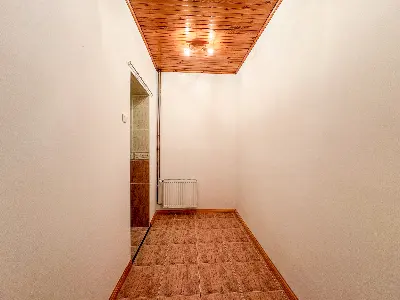 Mały pokój z drewnianym sufitem i grzejnikiem w mieszkaniu w centrum Łodzi