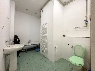 Łazienka z wanną, umywalką i grzejnikiem drabinkowym w kamienicy w Łodzi