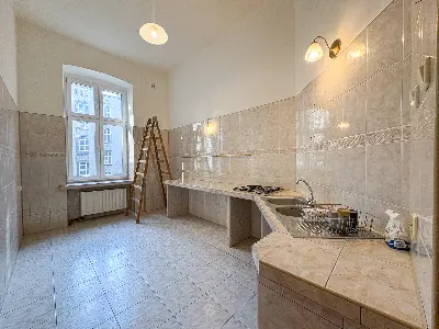 Przestronna kuchnia z kafelkami i oknem w kamienicy w Śródmieściu Łodzi