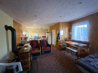 Wnętrze domku — salon z kominkiem i kuchnią w zabudowie