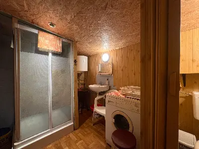 Łazienka z prysznicem i pralką w domku letniskowym
