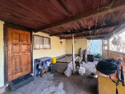 Zadaszony ganek wejściowy z drewnianymi drzwiami