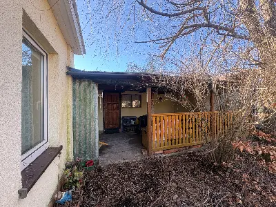 Wejście do domku z drewnianym gankiem i balustradą