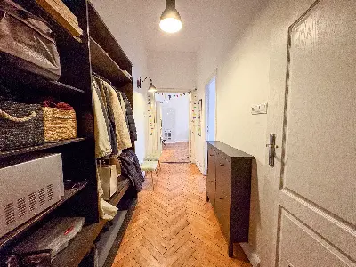 Korytarz z otwartą garderobą i parkietem w mieszkaniu na Polesiu