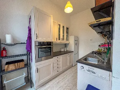 Kuchnia z białymi szafkami i piekarnikiem w mieszkaniu na Polesiu w Łodzi