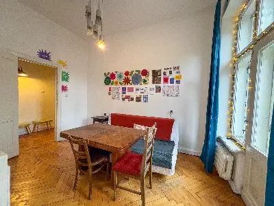 Salon z stołem jadalnym i kanapą na parkiecie w jodełkę w Łodzi