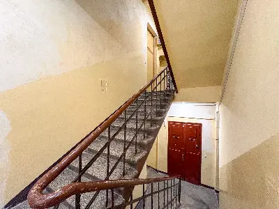 Klatka schodowa kamienicy z drewnianą balustradą i kamiennymi stopniami