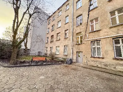 Podwórko kamienicy z ławką i heksagonalną nawierzchnią na Polesiu w Łodzi