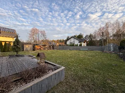 Ogród z podwyższonymi grządkami i szopą drewnianą przy domu w Księstwie