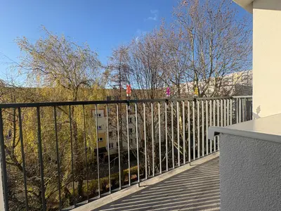 Balkon z widokiem na drzewa i osiedle w dzielnicy Bałuty w Łodzi