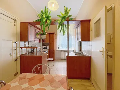 Kuchnia z drewnianymi szafkami i aneksem ze stołem – mieszkanie na sprzedaż Łódź Śródmieście, ul. Piotrkowska